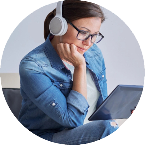 Woman with headphones looks into her tablet.